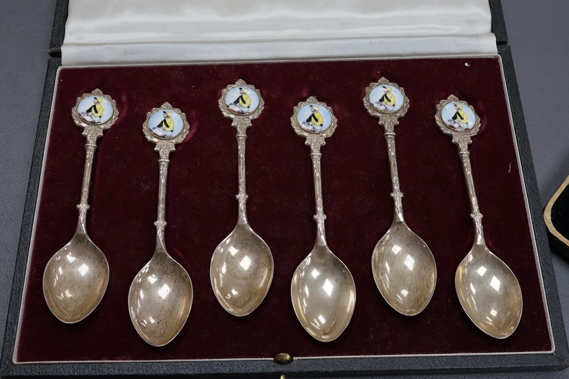 A cased set of six Elizabeth II silver teaspoons, the enamelled terminals decorated with a jockey in racing colours, maker JJW, Birmingham, 1978, together with a cased set of five (ex six) silver teaspoons and a cased se